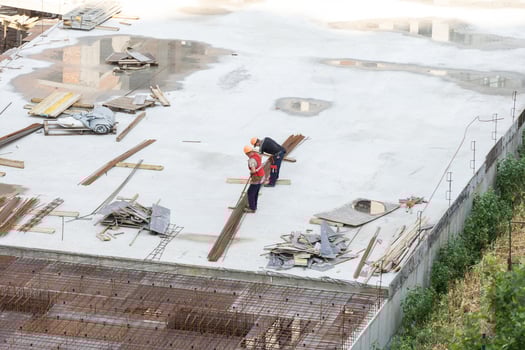 builder in orange helmet works, construction of multi-storey building or shopping center in city. modern architecture work on building object. monolithic skyscraper metal fittings, technologies photo
