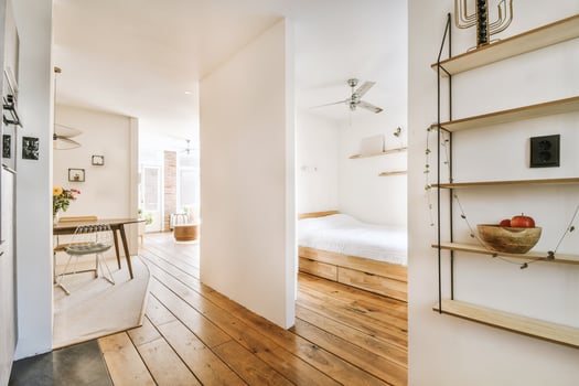 A small apartment with a bed, a table and a wooden floor photo