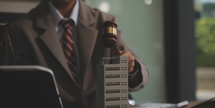 Real Estate Law, Home Insurance, property Tax, Auction and Bidding concepts. small toy house model with gavel justice hammer on desk in courthouse. photo