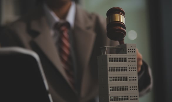 Real Estate Law, Home Insurance, property Tax, Auction and Bidding concepts. small toy house model with gavel justice hammer on desk in courthouse. photo