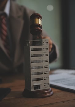 Real Estate Law, Home Insurance, property Tax, Auction and Bidding concepts. small toy house model with gavel justice hammer on desk in courthouse. photo