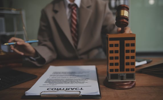 Real Estate Law, Home Insurance, property Tax, Auction and Bidding concepts. small toy house model with gavel justice hammer on desk in courthouse. photo