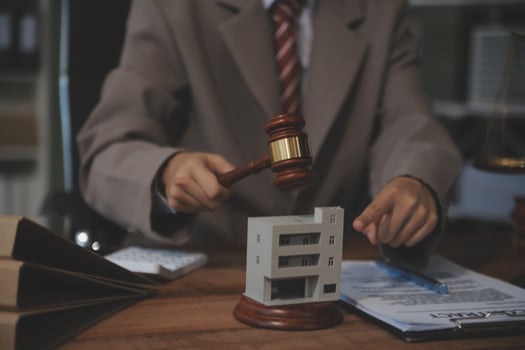 Real Estate Law, Home Insurance, property Tax, Auction and Bidding concepts. small toy house model with gavel justice hammer on desk in courthouse. photo