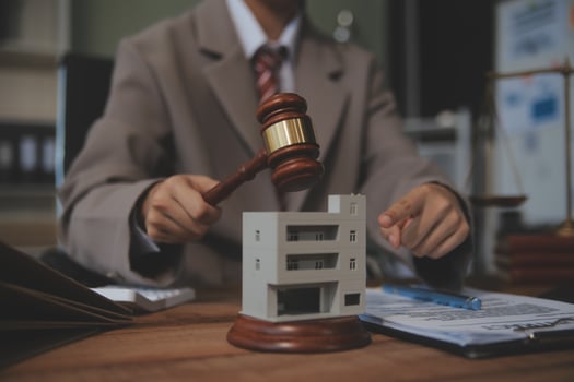 Real Estate Law, Home Insurance, property Tax, Auction and Bidding concepts. small toy house model with gavel justice hammer on desk in courthouse. photo
