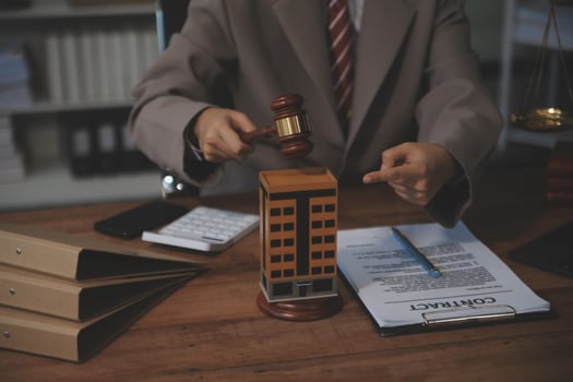 Real Estate Law, Home Insurance, property Tax, Auction and Bidding concepts. small toy house model with gavel justice hammer on desk in courthouse. photo