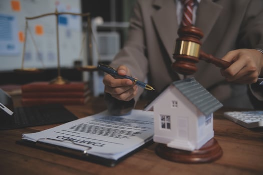 Real Estate Law, Home Insurance, property Tax, Auction and Bidding concepts. small toy house model with gavel justice hammer on desk in courthouse. photo