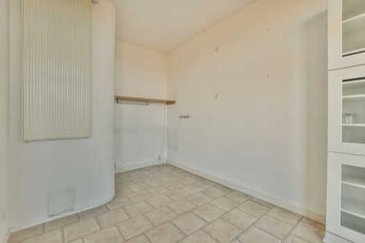 Empty room with white walls and tile flooring photo