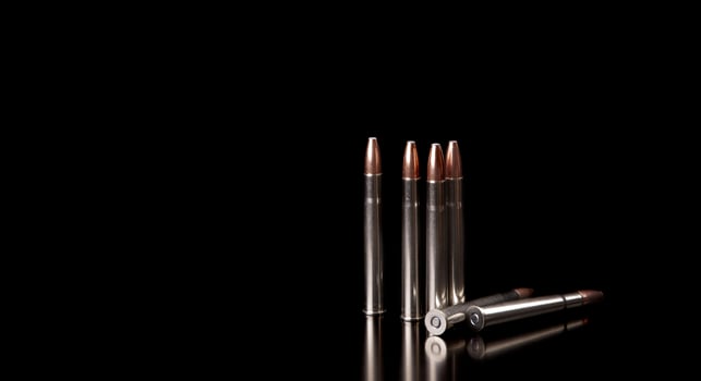 Bullet isolated on black background with reflexion. Rifle bullets close-up on black back. Cartridges for rifle and carbine on a black. photo