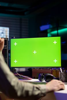 Man using isolated screen PC monitor to update artificial intelligence neural networks, writing binary code script. IT professional upgrading high tech AI using chroma key computer, close up photo