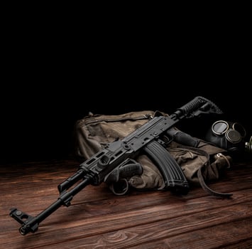 Soviet carbine in modern body kit. Weapons of Russia and the Soviet Union. Classic Soviet AK assault rifle and gas mask on a wooden back photo