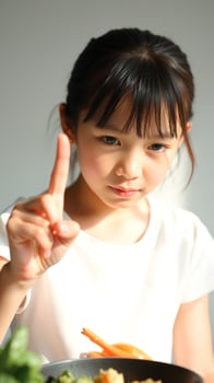 Young girl cooking and holding up finger photo