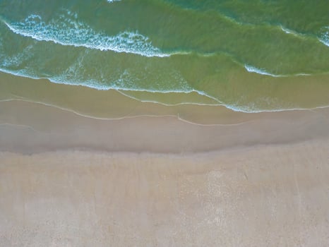 Relaxing aerial beach scene, summer vacation holiday template banner. Waves surf with amazing blue ocean lagoon, sea shore, coastline. Perfect aerial drone top view. Peaceful bright beach, seaside photo