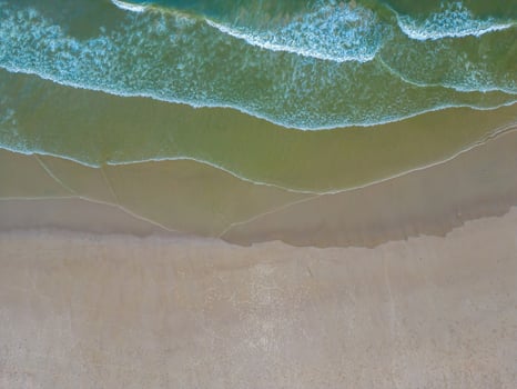 Relaxing aerial beach scene, summer vacation holiday template banner. Waves surf with amazing blue ocean lagoon, sea shore, coastline. Perfect aerial drone top view. Peaceful bright beach, seaside photo