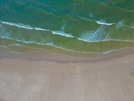Relaxing aerial beach scene, summer vacation holiday template banner. Waves surf with amazing blue ocean lagoon, sea shore, coastline. Perfect aerial drone top view. Peaceful bright beach, seaside photo