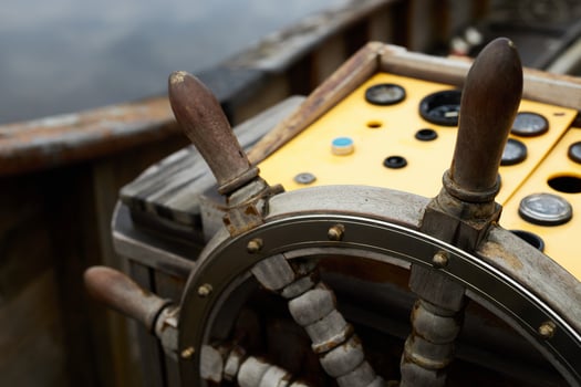 A close-up view of a wooden ship's wheel on a boat photo