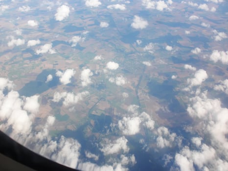 View from airplane window. White clouds above the land. photo