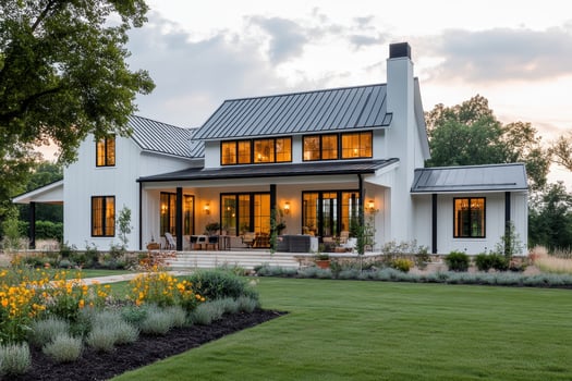 A modern farmhouse with a welcoming porch and landscaped garden at dusk photo