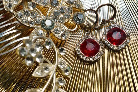 a pair of earrings and a brooch on a gold background photo