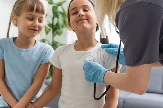 Female pediatrician doctor communicates with little girl photo