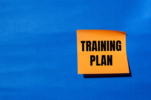 Training plan message written on orange paper with blue background. Conceptual training plan symbol. Copy space. photo