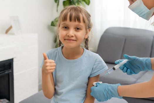Little girl getting vaccination from pediatrician at medical office photo