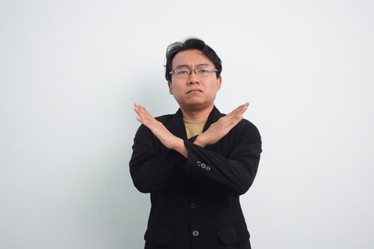 Asian Businessman with casual suit and shirt in studio showing cross hand as no or rejection, deny, prohibition with isolated white background photo