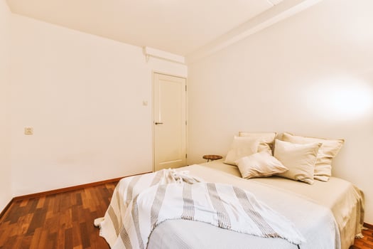 A bedroom with a bed and wooden floors photo