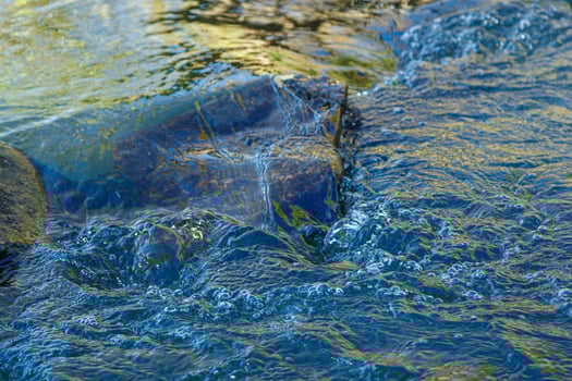 flow of water and spray from a stone photo