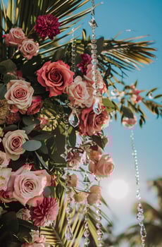 Beautiful festive arch decoration of roses, greenery and tropical leaves with crystal bead garlands. photo