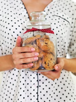 Happy woman holding jar with coockies photo