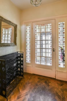 A hallway with a mirror and a wine rack photo