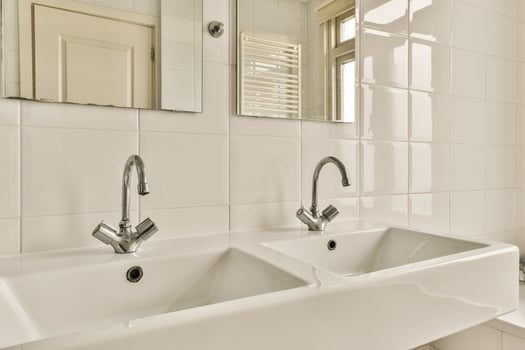 A bathroom with two sinks and a mirror photo