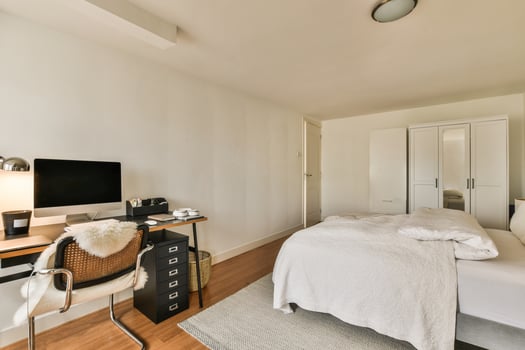 A bedroom with a desk and a bed photo
