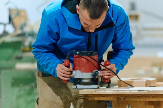 Close Up of Worker Carefully Cutting and Planing Wooden Pieces for Furniture in Wood Industry photo