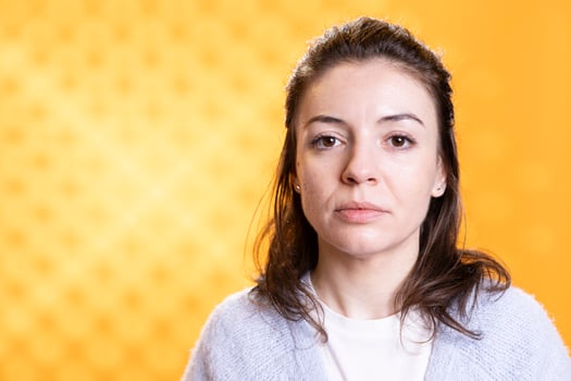 Portrait of optimistic woman posing, feeling happy and relaxed, isolated over yellow studio background. Close up shot of lively radiant caucasian lady standing, looking at camera photo