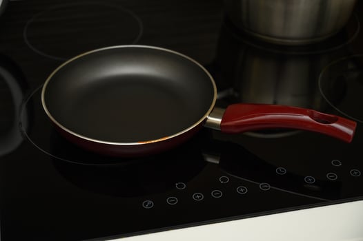 Black frying pan on an electric stove, minimalist kitchen background photo