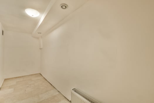 A white room with a white wall and a white radiator photo