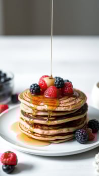 Delicious pancakes with fresh berries and syrup photo