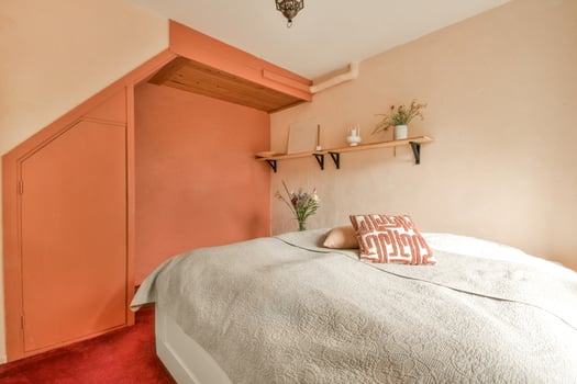 A bedroom with orange walls and a bed photo