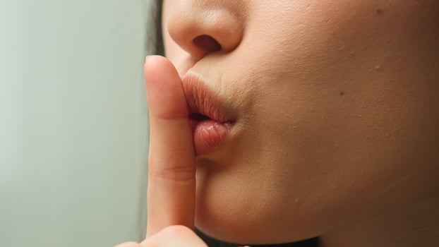 Close up female mouth Asian chinese korean japanese girl unrecognizable woman showing hush lips secret silence quite secrecy confidential mysterious whisper silent hand gesture face details in studio photo