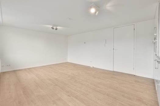 An empty room with wooden floors and white walls photo