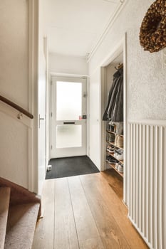 A hallway with a door and a coat rack photo