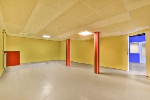 An empty room with yellow walls and red pillars photo
