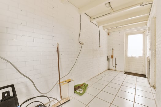 A white brick wall with a door and a hose photo