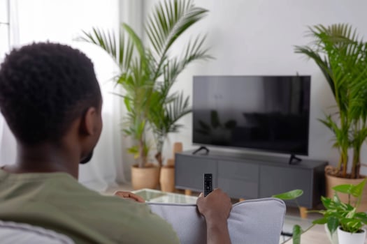 Person watching tv television series sofa retro spooky show documentary movie film couch sitting dark motion picture horror setting home cinema choosing channel remote control photo