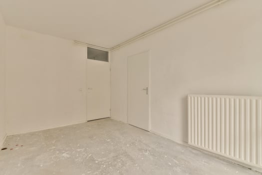 An empty room with a radiator and a door photo