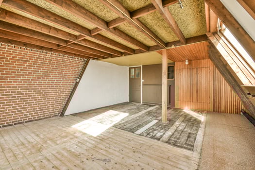 A room with a brick wall and wooden beams photo