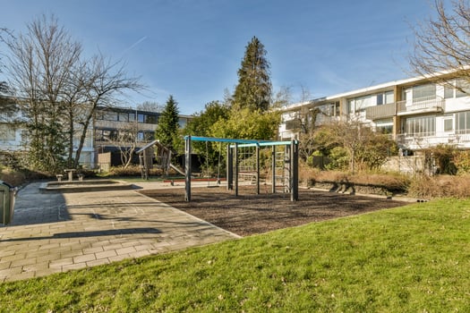 An apartment complex with a playground and a grassy area photo
