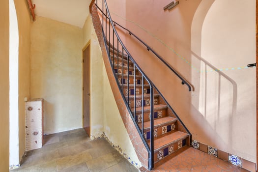 A stairway with a handrail and a door photo