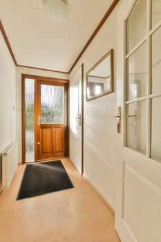 A hallway with a door and a black mat photo